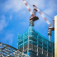 新宿の建設現場の建物屋上にそびえるクレーンの写真