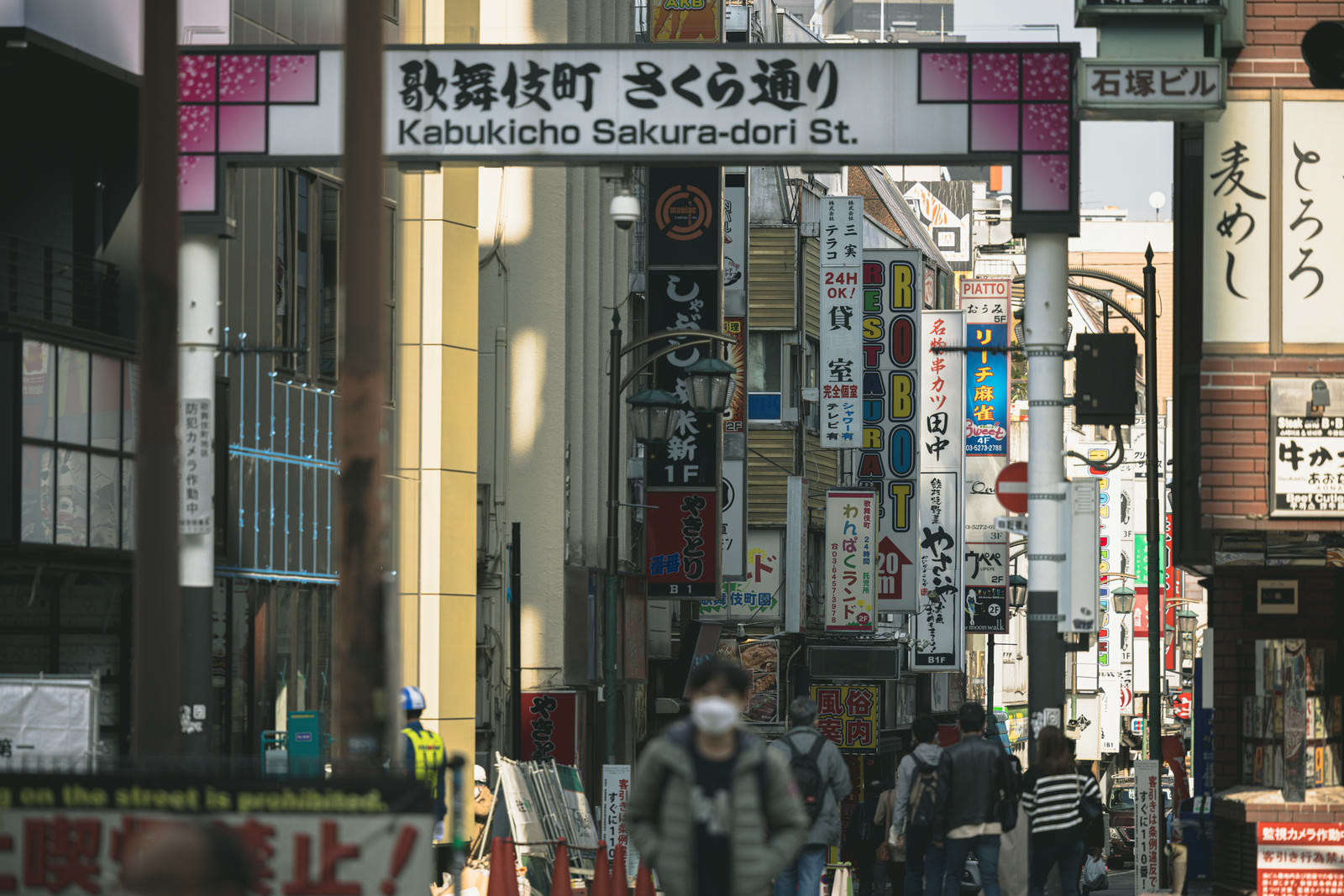 歌舞伎町さくら通り沿いに看板や突出し看板が並ぶ繁華街の風景
