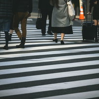 新宿の横断歩道を渡る人々の足元 白線上を歩く人々の写真
