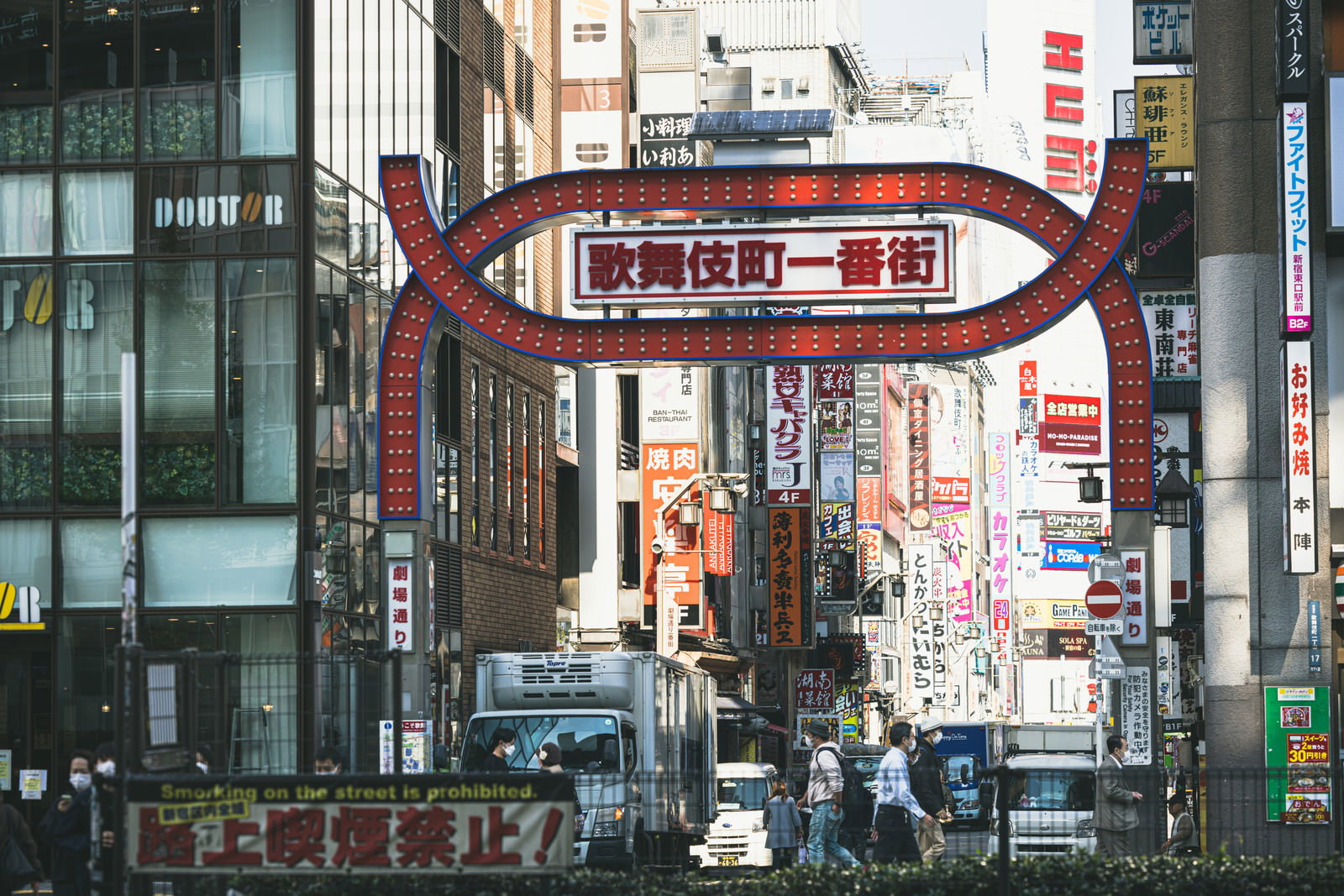 新宿歌舞伎町一番街の赤いアーチ看板と多数の袖看板が並ぶ夜の街並み