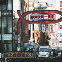昼間の新宿歌舞伎町一番街の入り口と赤いアーチ看板の写真
