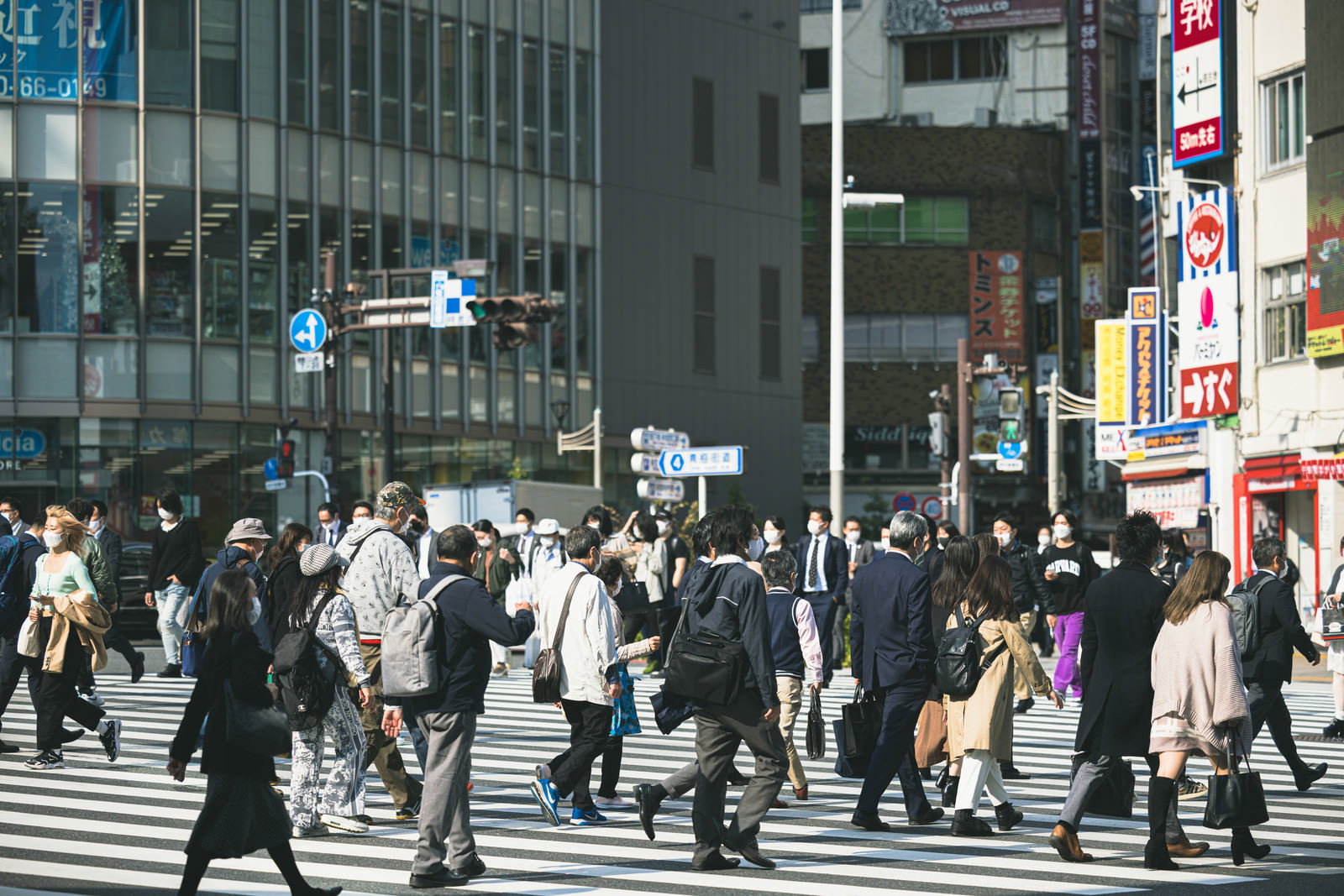 新宿の横断歩道を大勢の人が渡っている都市の交通風景