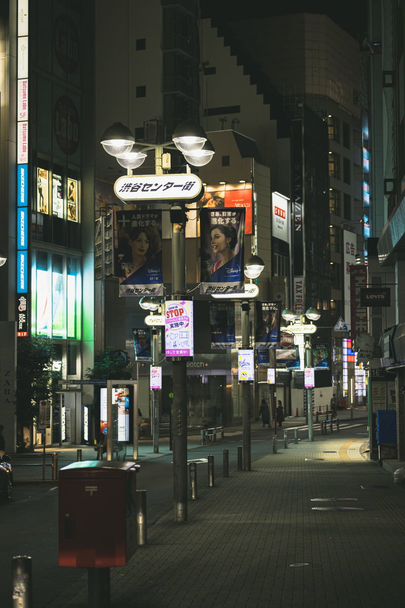 深夜の渋谷センター街。無人の商店街に街灯と看板が光る