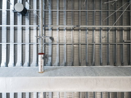 金属製の配管が通った工業的な天井の構造体