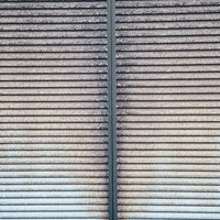 鎧戸全体に広がった錆のテクスチャーと劣化した金属表面の写真