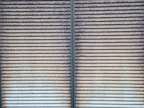 鎧戸全体に広がった錆のテクスチャーと劣化した金属表面