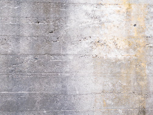 茶色のシミが残るコンクリート擁壁のテクスチャ