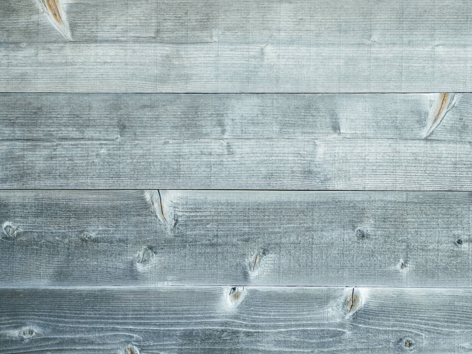 細かい節模様が入ったグレー系の色あせた木製板壁のテクスチャ