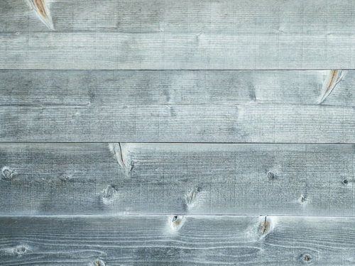 細かい節が残る色あせた板壁のテクスチャ背景