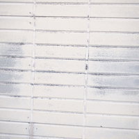 擦れ跡残るホワイト色のタイル壁テクスチャの写真
