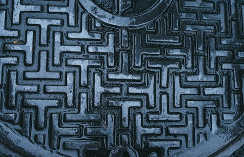 雨上がりのアスファルト道路に光るマンホールの蓋