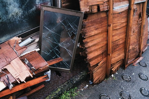 廃家から出された割れたガラスと木材の廃棄物