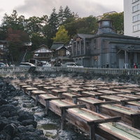 夕暮れ時の草津温泉、湯畑を望む温泉街の源泉風景の写真