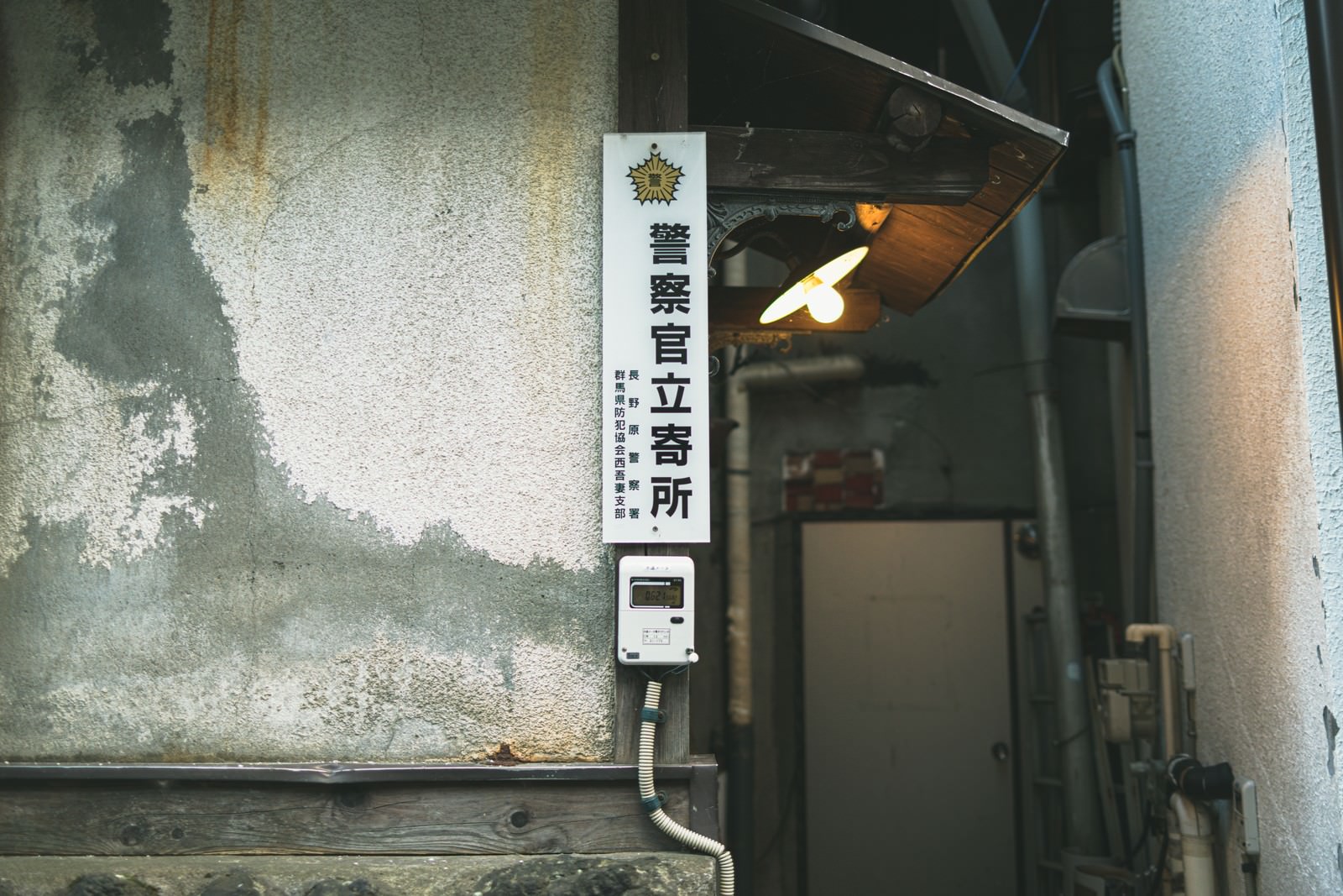 古い建物の壁に設置された白い警察官立寄所のプレート