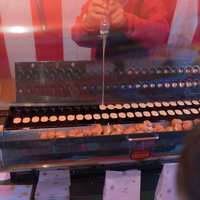 ベビーカステラを焼く出店の屋台で調理する職人の写真