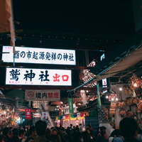 夜の鷲神社の酉の市、境内に並ぶ出店と参拝者の群れの写真