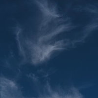 深い青空に薄く流れる白い雲と昼間の快晴の空模様の写真