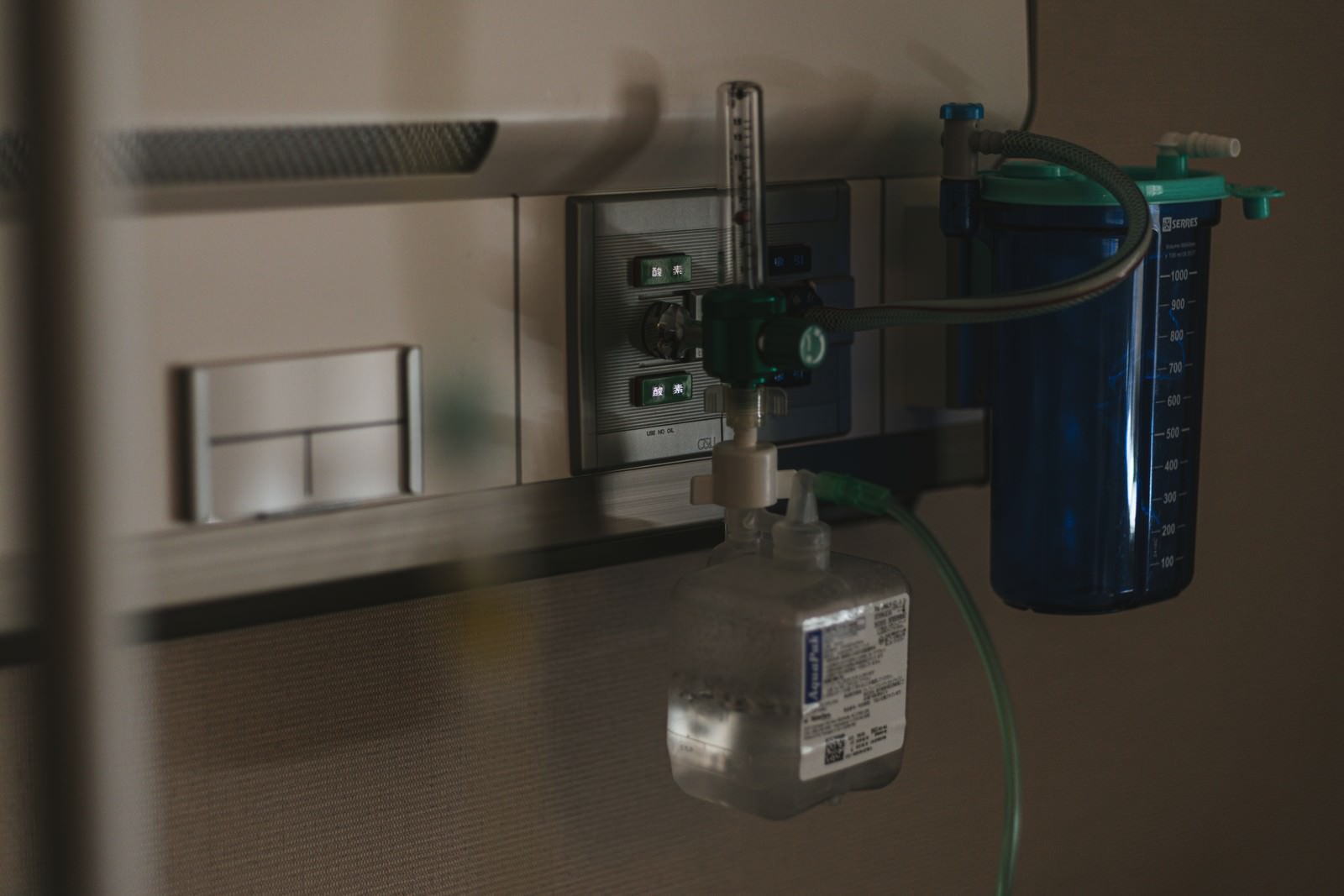 Oxygen inhaler with a blue oxygen cylinder and a control panel installed on the wall