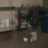 病院に設置された酸素吸入器の医療機器と酸素ボンベの写真