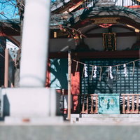 浅間神社の境内に置かれた朱色の柱と木製の賽銭箱の写真