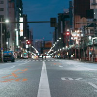 夜の街の車道に引かれたセンターラインと街並みの写真