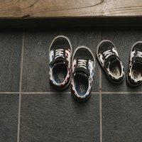 玄関のグレータイル床に脱ぎっぱなしの子供の靴のペアの写真