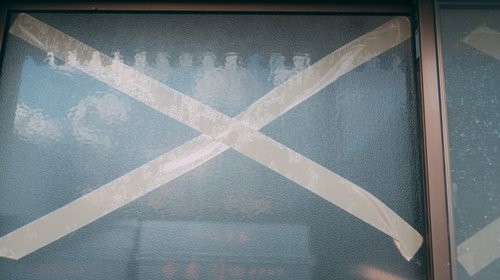 強風でガラス窓が割れないように貼られた茶色のガムテープ