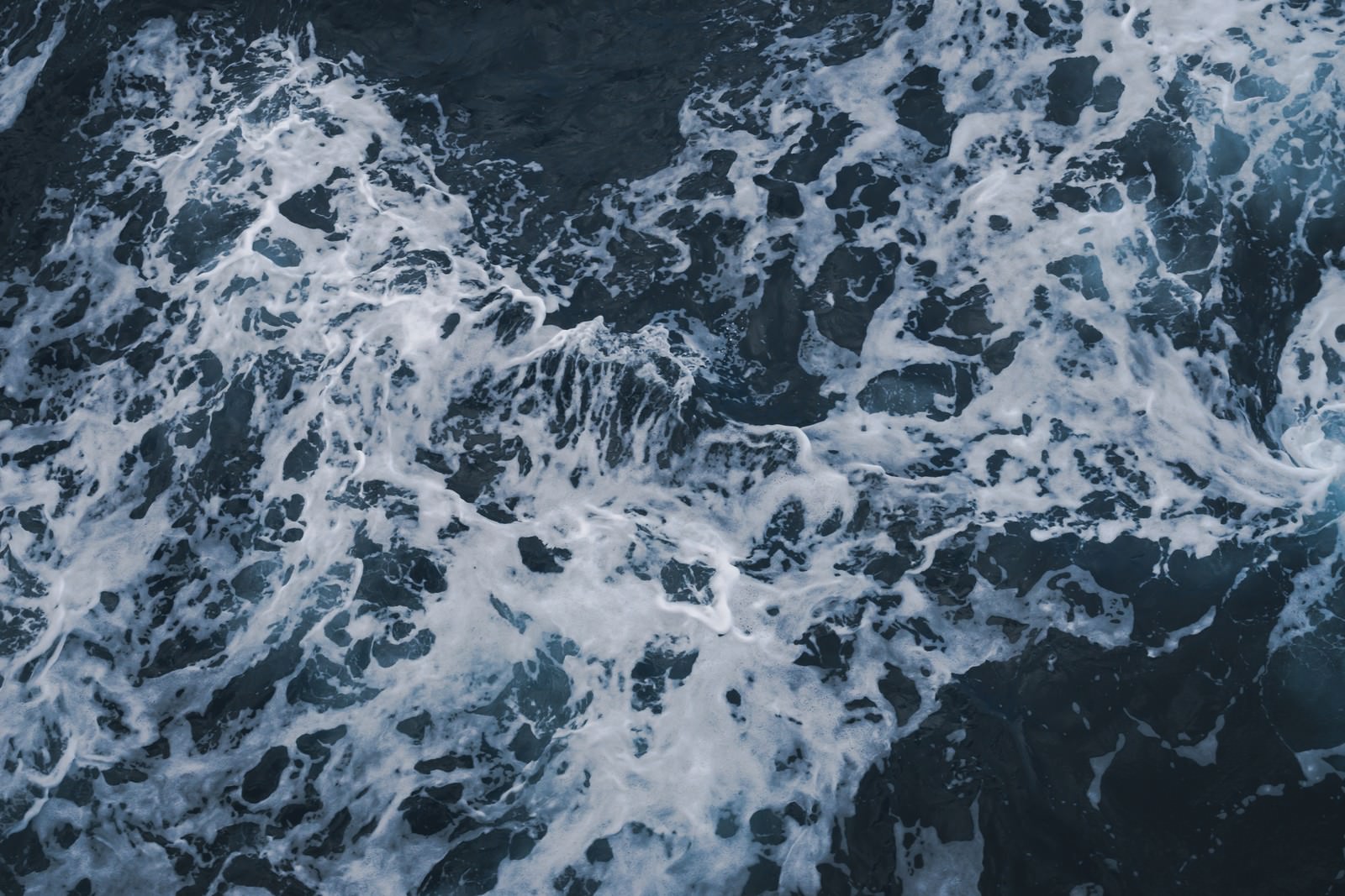 白い泡が波打つ水面に広がる動的なテクスチャの様子