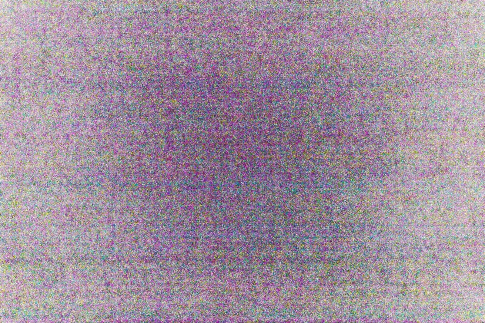 紫とグレーの粒状ノイズが全面に広がるテレビの砂嵐画面