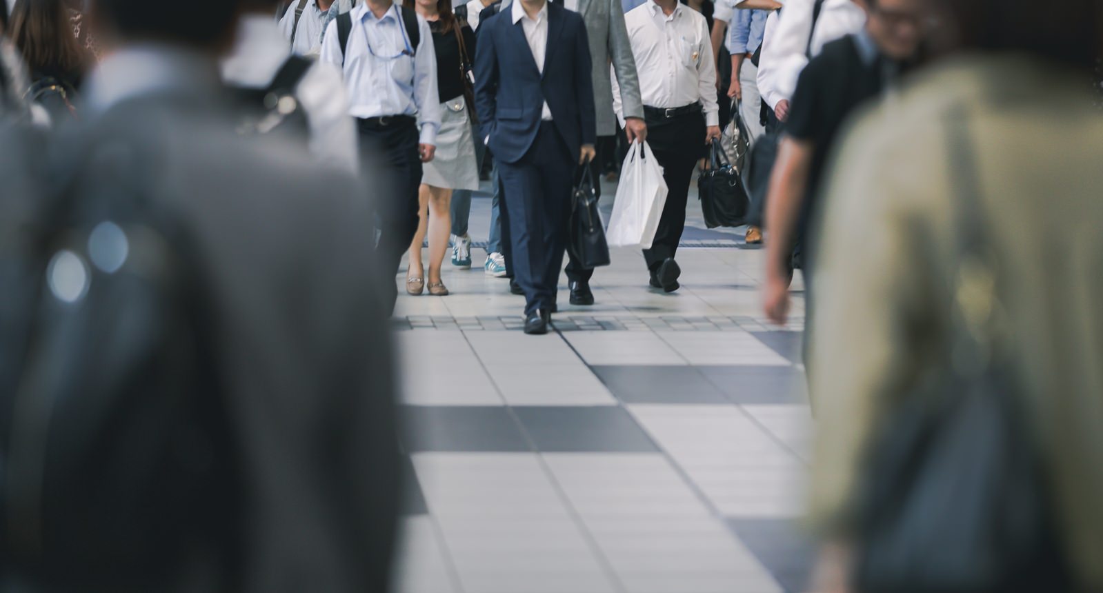 ぼかしで表現された人混みラッシュ時の通勤風景