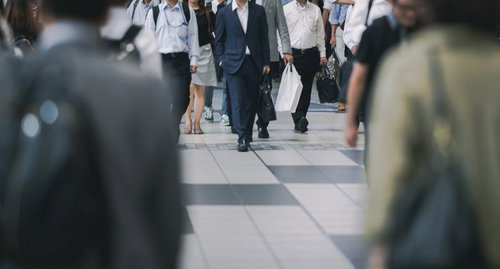 駅前の人混みラッシュ時の通勤風景と往来する多くの歩行者
