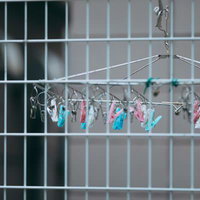金属製の柵越しに吊り下げられたピンチハンガーの写真