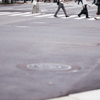 都市部の横断歩道を渡る歩行者たちの写真