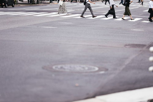 都市部の横断歩道を渡る歩行者たち