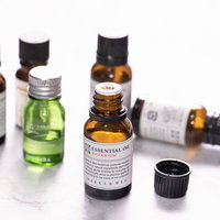 蓋の開いたエッセンシャルオイルと複数のアロマオイルの瓶の写真