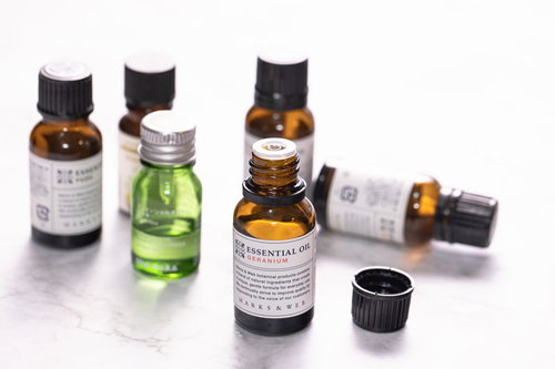 蓋の開いたエッセンシャルオイルと複数のアロマオイルの瓶