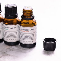 蓋の開いた複数のエッセンシャルオイル瓶とアロマオイルボトルの写真