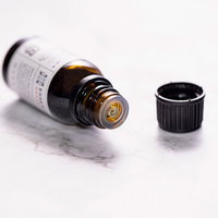 倒れて蓋の開いたエッセンシャルオイルの小瓶の写真