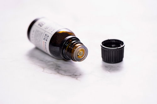 倒れて蓋の開いたエッセンシャルオイルの小瓶