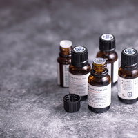 蓋の開いた複数のアロマオイルの小瓶、香りが立ち上るの写真