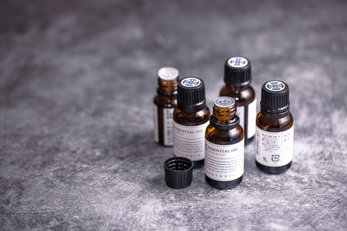 蓋の開いた複数のアロマオイルの小瓶、香りが立ち上る