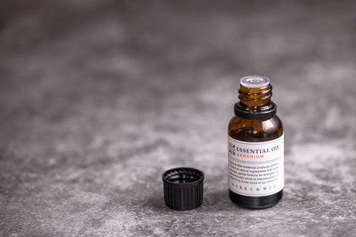 試嗅用に蓋の開いた茶色の小瓶のエッセンシャルオイル