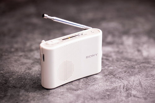 コンクリートの床に置かれた白いラジオのアンテナ