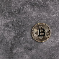 コンクリート床に置き忘れた金貨のようなビットコインの写真
