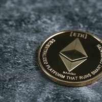 卓上に置かれた金色のイーサリアムコイン、ETH仮想通貨投資の写真