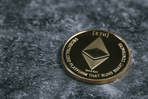 卓上に置かれた金色のイーサリアムコイン、ETH仮想通貨投資