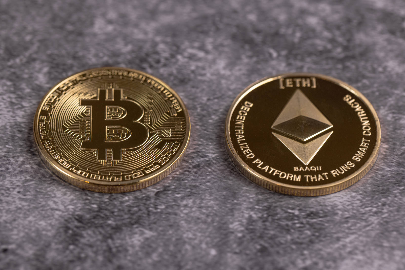 金色のビットコインとイーサリアムのコインが並んで置かれている