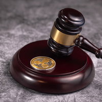 ジャッジガベルに打たれるリップルコイン、仮想通貨の法的規制の写真