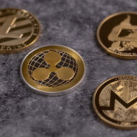 集めた四枚の暗号通貨コイン（LTC、DASH、XRP、XMR）の写真