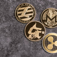 金色の暗号通貨コイン4枚（LTC, DASH, XRP, XMR）の写真
